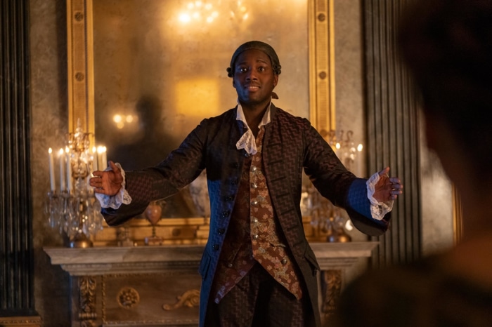 Man in 18th-century attire in a grand room