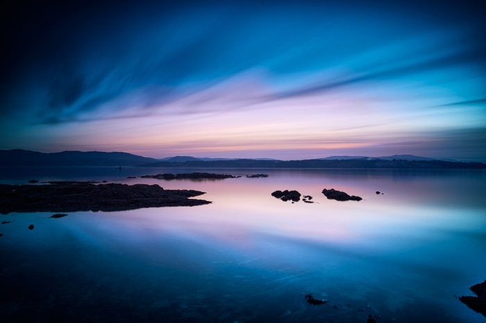 Sunset over water with islands and mountains
