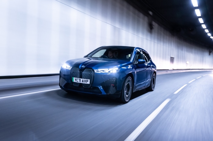 Blue BMW iX xDrive40 Sport driving in tunnel
