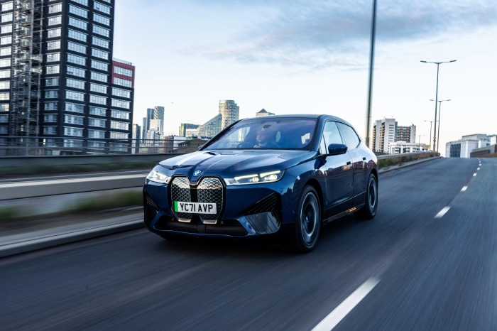 Blue BMW iX xDrive40 Sport driving on a road