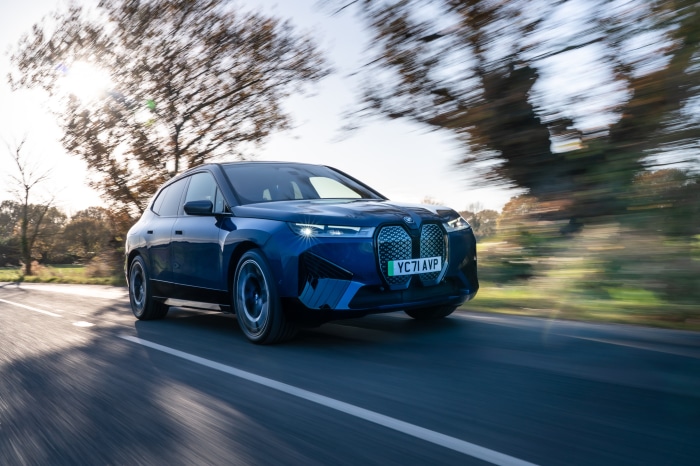 Blue BMW iX xDrive40 Sport SUV driving on a road