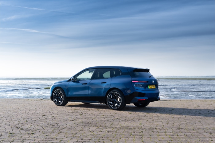 Blue BMW iX xDrive40 Sport SUV parked by the sea