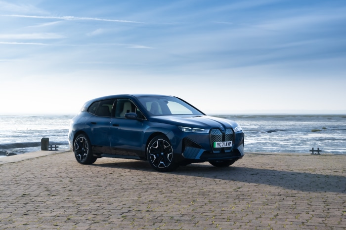 Blue BMW iX xDrive40 Sport SUV parked by the sea