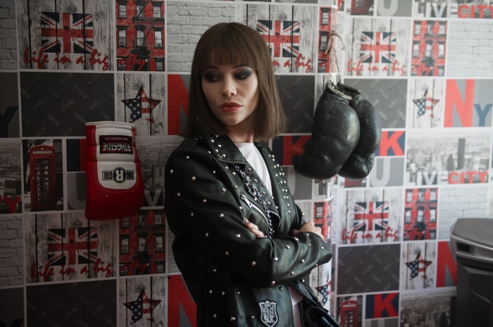 Woman in studded leather jacket with boxing gloves