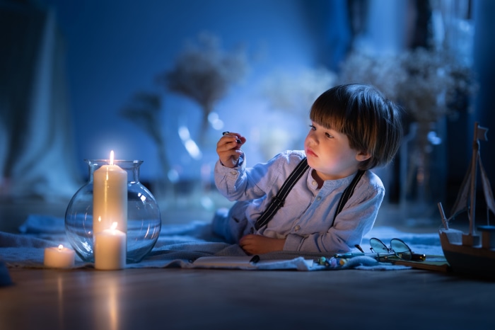 Boy with candles and toy boat