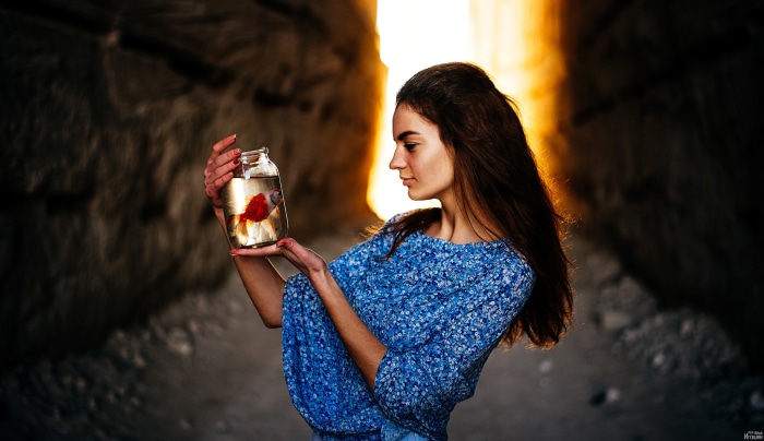 Girl holding a goldfish in a jar