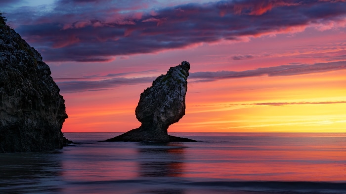 Rock formation in the ocean at sunset