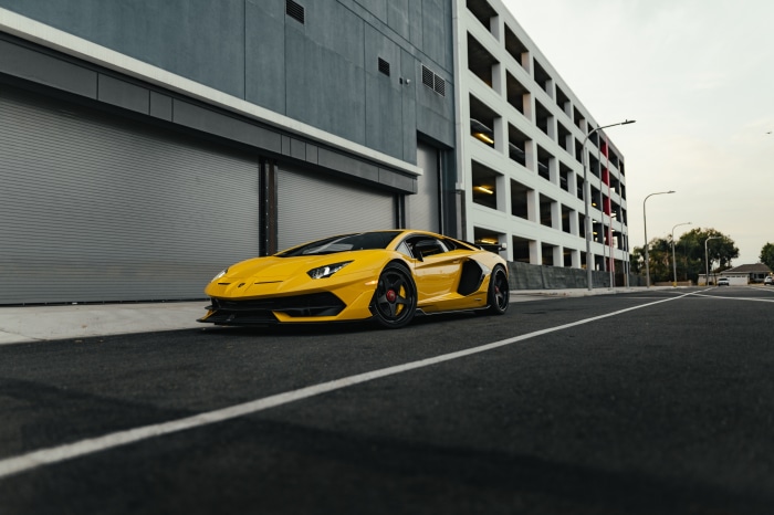 Yellow Lamborghini Aventador SVJ parked on asphalt road