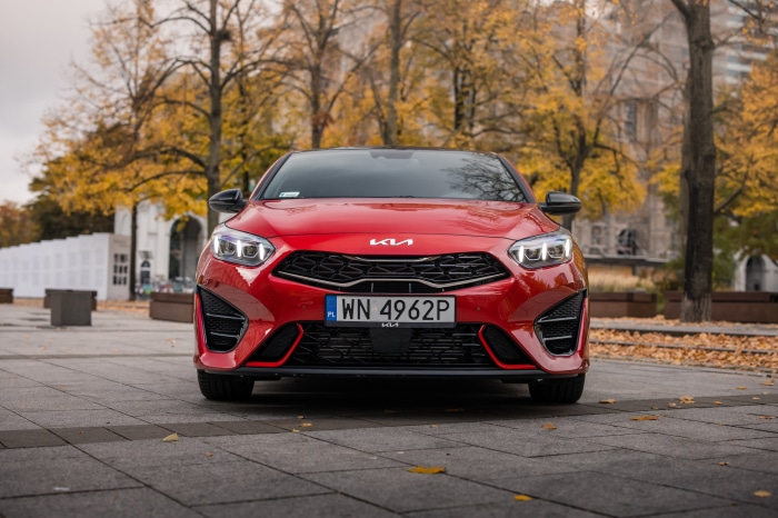 Red Kia Ceed GT parked outdoors in autumn