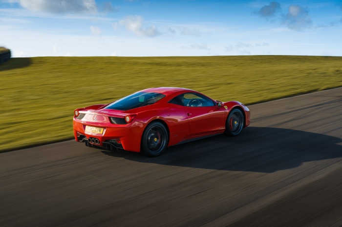 Red Ferrari 458 Italia driving on a track
