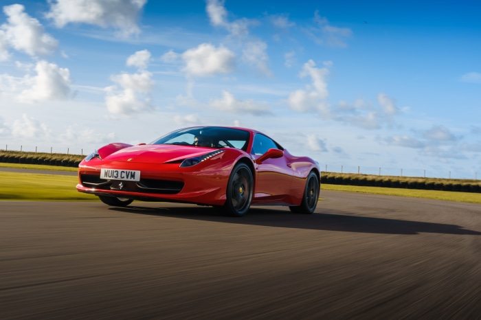 Red Ferrari 458 Italia driving on a track