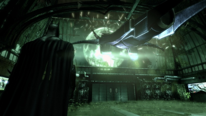 Batman in a hangar with a Batwing and a large moon