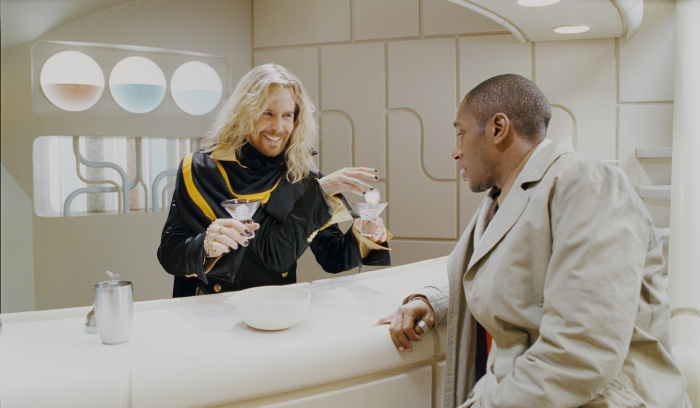 Yasiin Bey and Sam Rockwell as Zaphod Beeblebrox and Ford Prefect