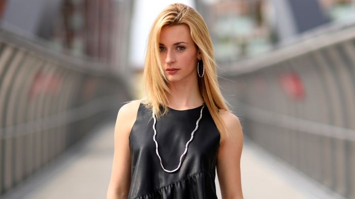 Model wearing black dress and necklace