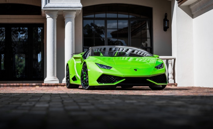 Green Lamborghini Huracan parked in front of a house