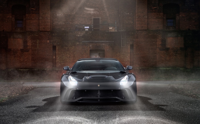 Black Ferrari F12berlinetta parked in front of brick building