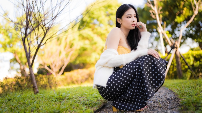 Asian woman in polka dot skirt in park 4K