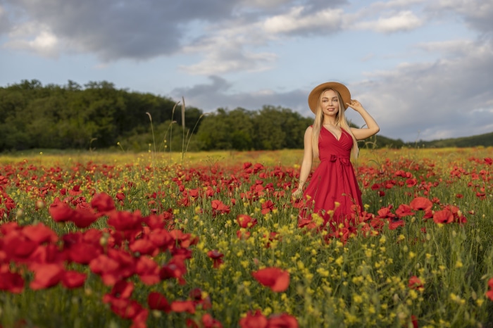 Woman in red dress in poppy field
