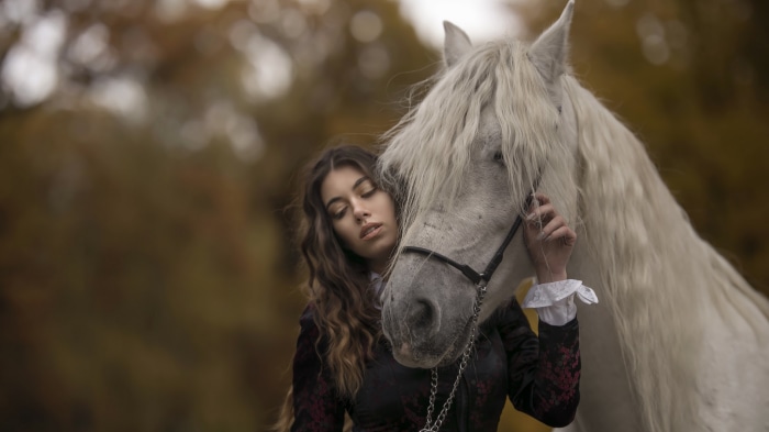 Woman with white horse in autumn