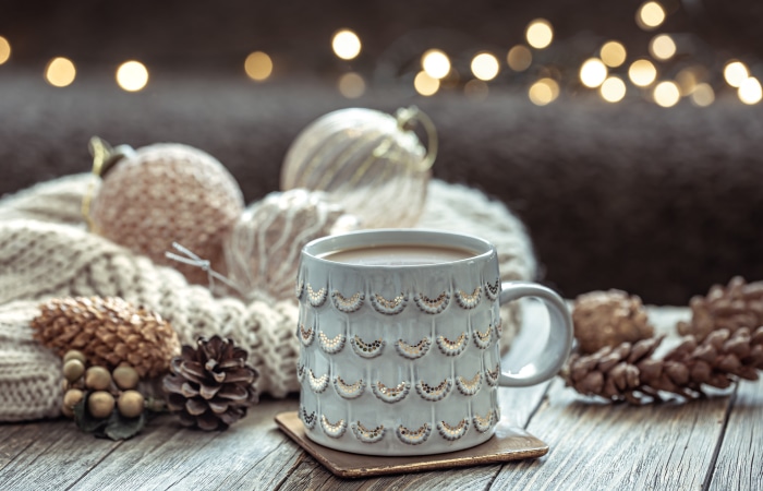 Coffee cup with Christmas ornaments and pine cones