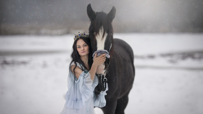 Woman in crown with horse in snow