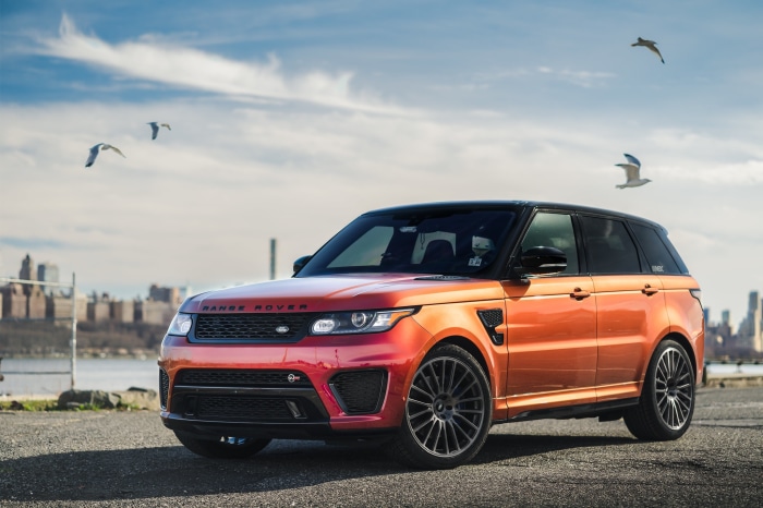 Orange Range Rover Sport SUV by the water