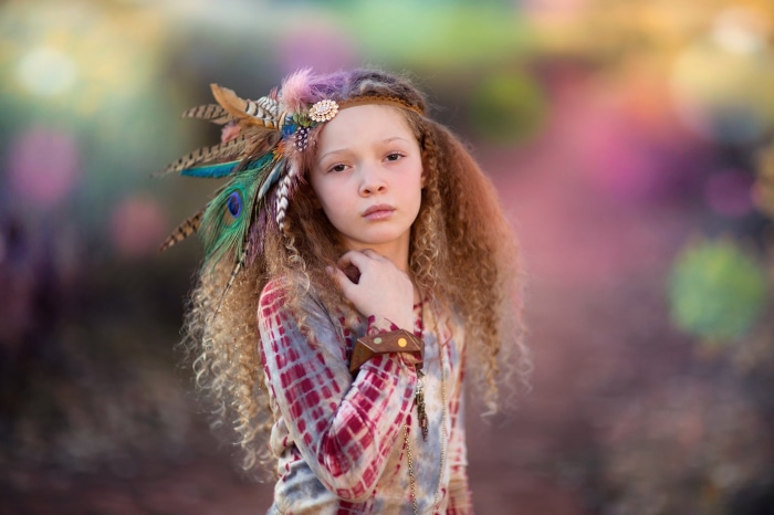 Girl with feather headdress and tie-dye shirt