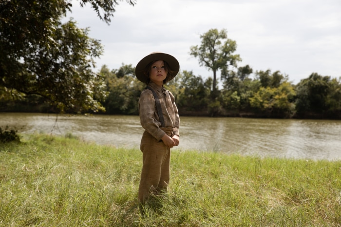Boy in hat by river