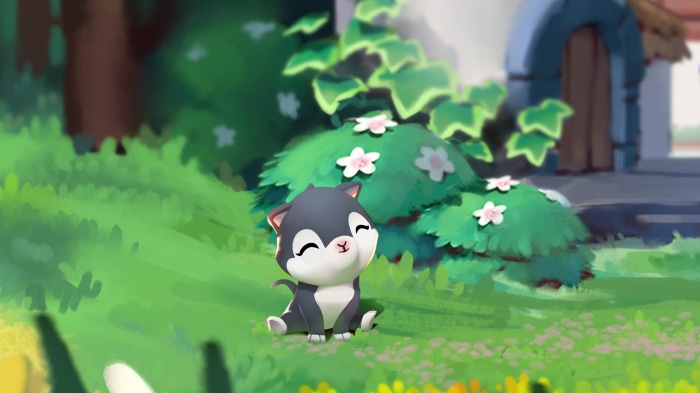 Cute kitten sitting in a grassy field with flowers