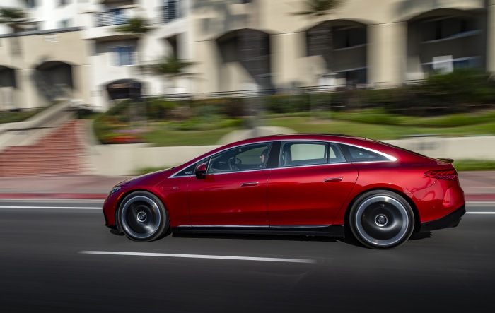 Red Mercedes-AMG EQS 53 4MATIC driving on road