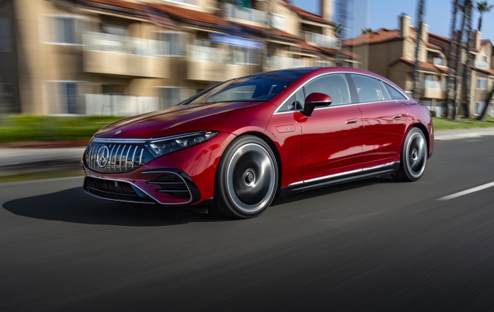Red Mercedes-AMG EQS 53 4MATIC driving on a road