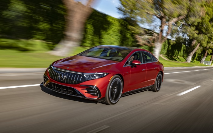 Red Mercedes-AMG EQS 53 4MATIC driving on a road