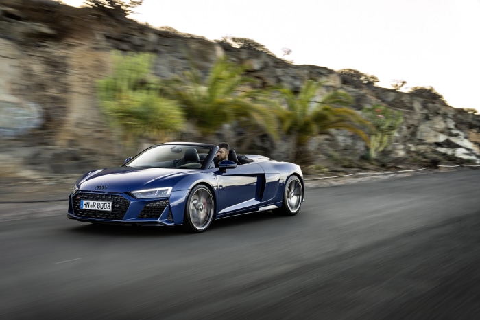 Blue Audi R8 V10 Convertible driving on a road