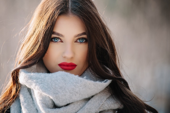 Woman with blue eyes and red lipstick wearing a scarf