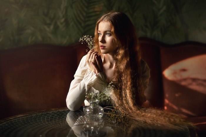Redhead woman with long hair holding flowers