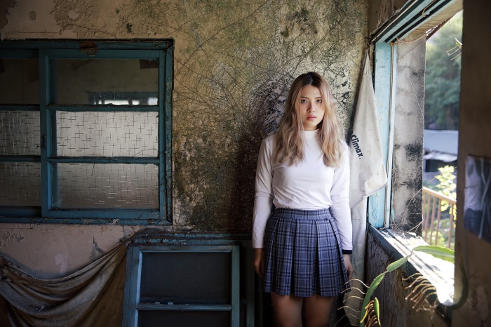 Young Asian woman in school uniform in abandoned building