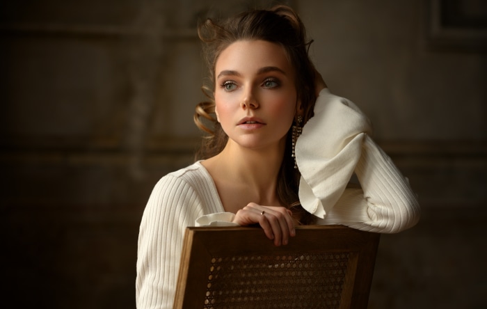 Woman in white sweater sitting on a chair