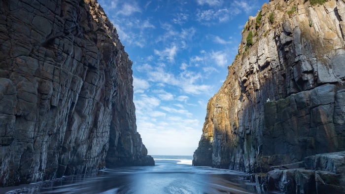 Dramatic sea cliffs framing the ocean under a cloudy sky