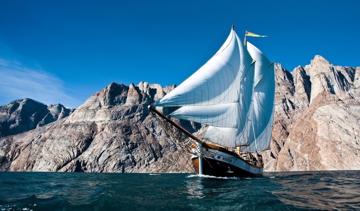Sailing ship on the water with mountains