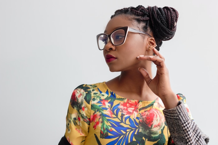 Woman with braided hair and glasses wearing a floral top