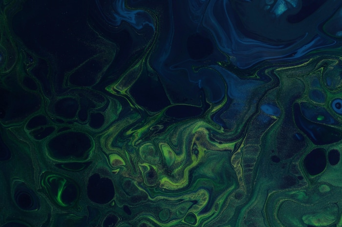Abstract dark blue and green fluid art with glitter