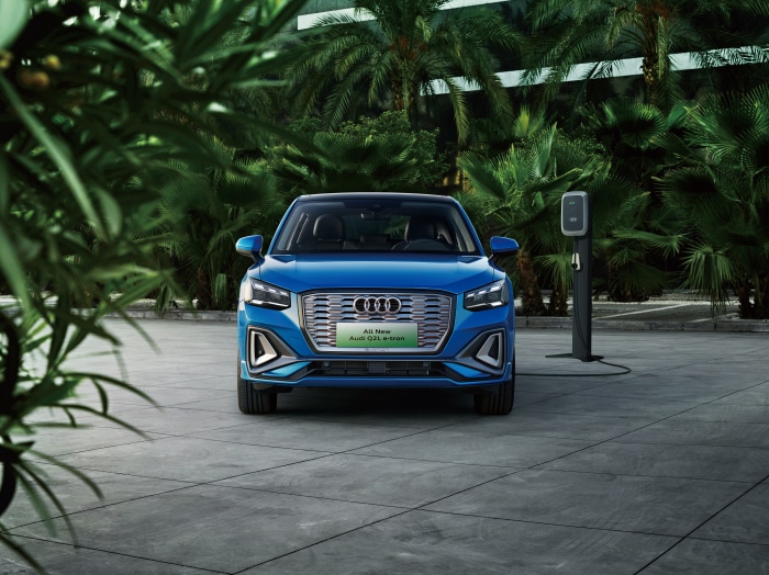 Blue Audi Q2L e-tron parked near charging station