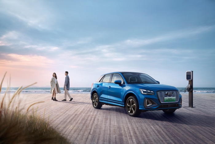 Audi Q2 L e-tron electric SUV charging on beach