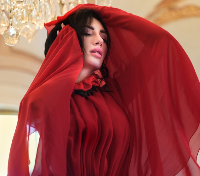 Woman in red dress under chandelier
