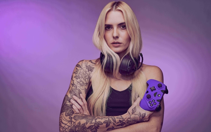 Woman with tattoos holding a purple game controller