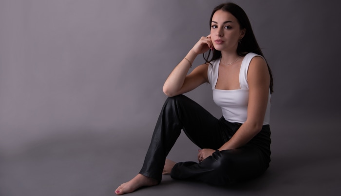 Model sitting on a grey background