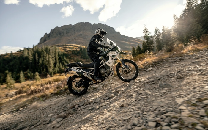 Triumph Tiger 1200 Rally Pro motorcycle on a rocky mountain trail
