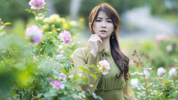 Asian woman with long brown hair in a garden