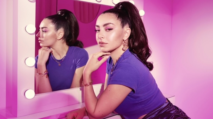Charli XCX in front of a mirror with lights