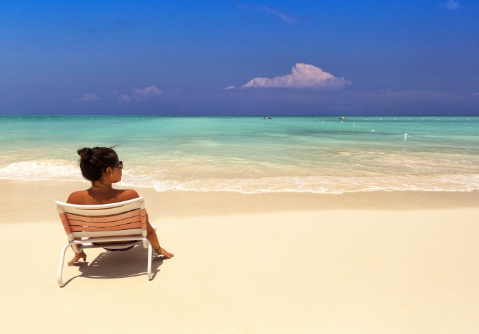 Woman relaxing on a beach chair in Grace Bay, Turks and Caicos